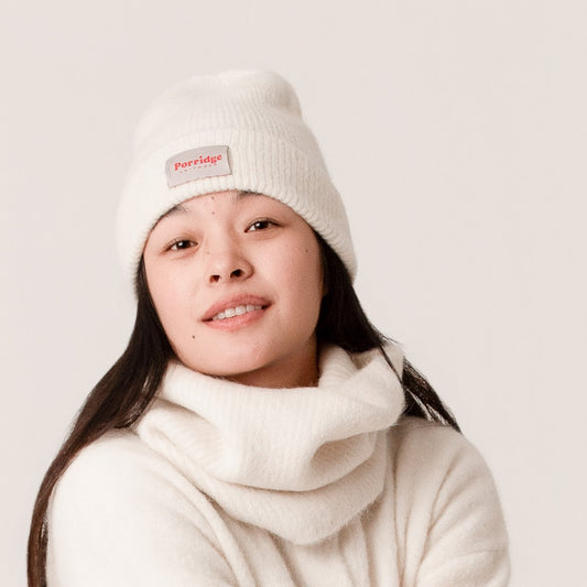 Person wearing a cream knitted beanie with a matching snood by Porridge Knitwear