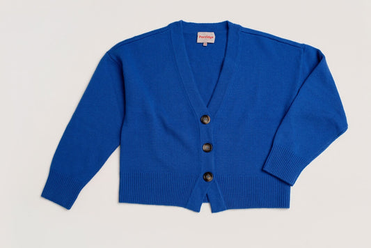 Blue wool and cashmere cardigan with tortoiseshell buttons on a plain background