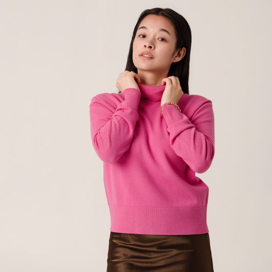 Person wearing a pink wool and cashmere polo neck