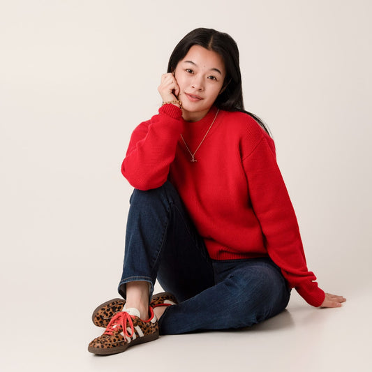 warm red cashmere and wool jumper with jeans and animal print trainers