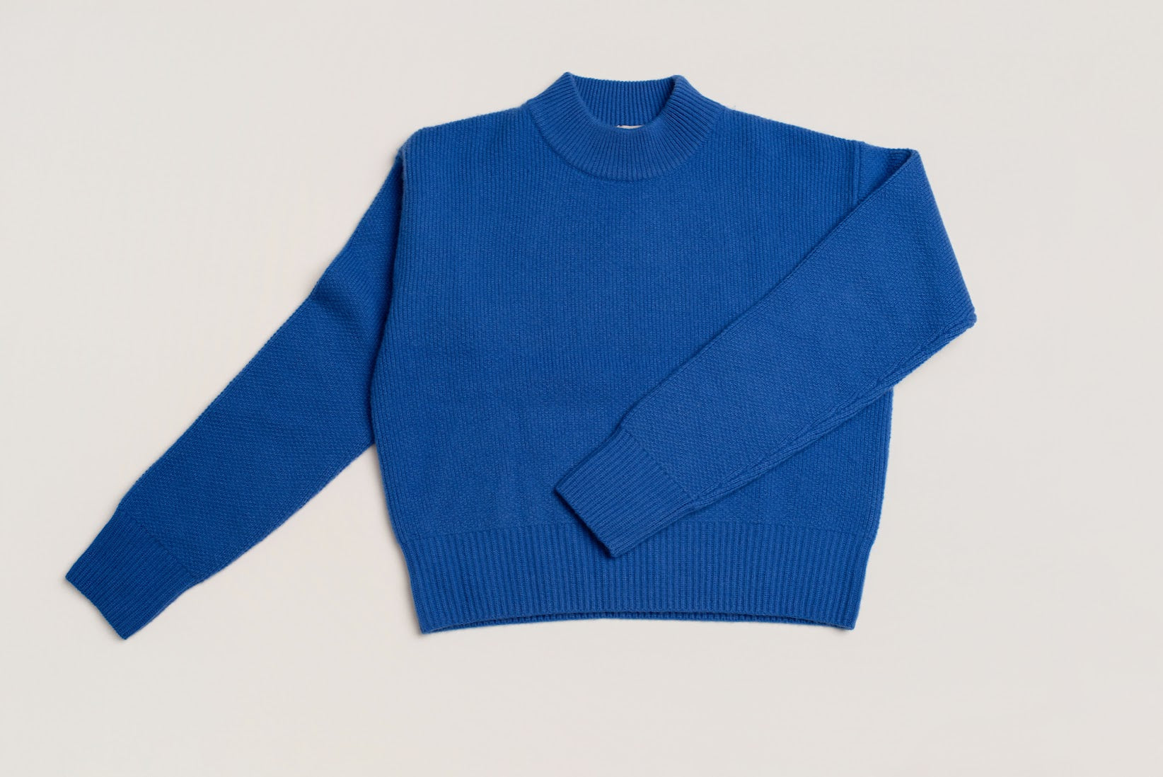Blue wool and cashmere sweater laid flat